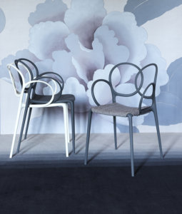 two driade design chairs ahead a wallpaper decorated wall